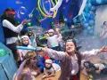 Dzieci w strojach piratów i wróżek bawią się na podwodnym balu karnawałowym. Balony i dekoracje tworzą atmosferę morskiej przygody.