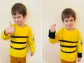 Chłopiec w żółtej bluzce w czarne pasy, idealny na strój pszczółki. Pokazuje kciuk w górę, jak zrobić strój pszczółki dla chłopca.