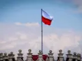 Biało-czerwona flaga powiewa na maszcie nad zabytkowym budynkiem. Wiatr rozwiewa ją, jakby niosła słowa o Polsce.