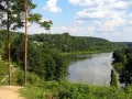 Malowniczy widok na rzekę Niemen, otoczoną lasami. W oddali widać kopułę kościoła, przykłady nazwy własne.