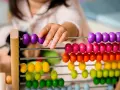 Dziecko bawi się kolorowymi liczydłami, ucząc się liczyć. To świetna zabawa edukacyjna!