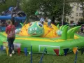 Dzieci bawią się na dmuchanej gąsienicy, która jest jedną z atrakcji na dzień dziecka.