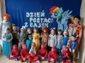 Dzień postaci z bajek w przedszkolu. Dzieci przebrane za Spider-Manów, księżniczki, zwierzątka i inne bajkowe postacie pozują do zdjęcia.