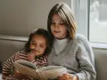 Mama czyta dziecku bajkę, pokazując, jak zachęcić dziecko do czytania. Wspólne chwile z książką budują więź i rozwijają wyobraźnię.
