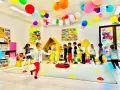 Kolorowe balony i girlandy ozdabiają salę, gdzie dzieci biorą udział w wesołych zajęciach plastycznych w przedszkolu.