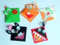 Pięć kolorowych zakładek do książki diy: zielony potwór, pomarańczowy tygrys, biała sowa, czarny zwierzak i czerwony potwór z zębami.