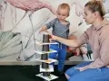 Mama i synek budują wieżę z kubeczków, ćwicząc naukę angielskiego dla 4 latka.
