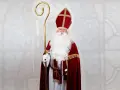 Postać w stroju biskupa z białą brodą i pastorałem. Tak wyglądał święty Mikołaj, który przynosił prezenty.