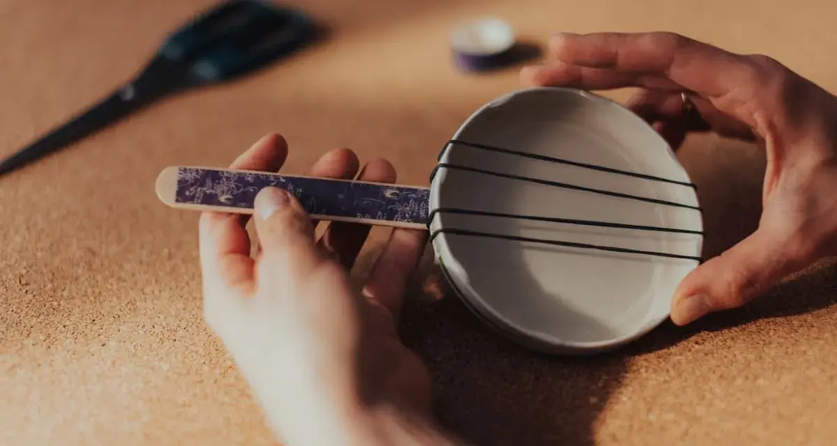 Ręce składają proste instrumenty muzyczne do zrobienia: miseczkę z gumkami i patyczek.