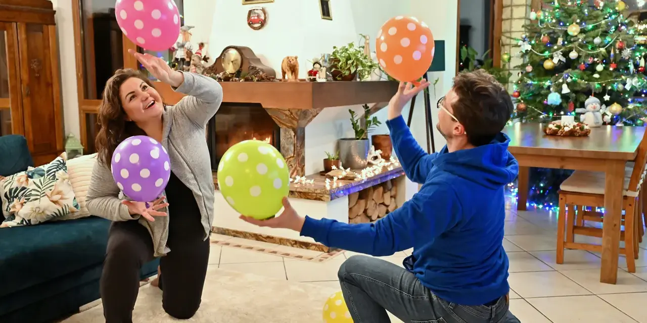 Para wiedzą, co robić, gdy się nudzi w domu: grają w balony przy choince.