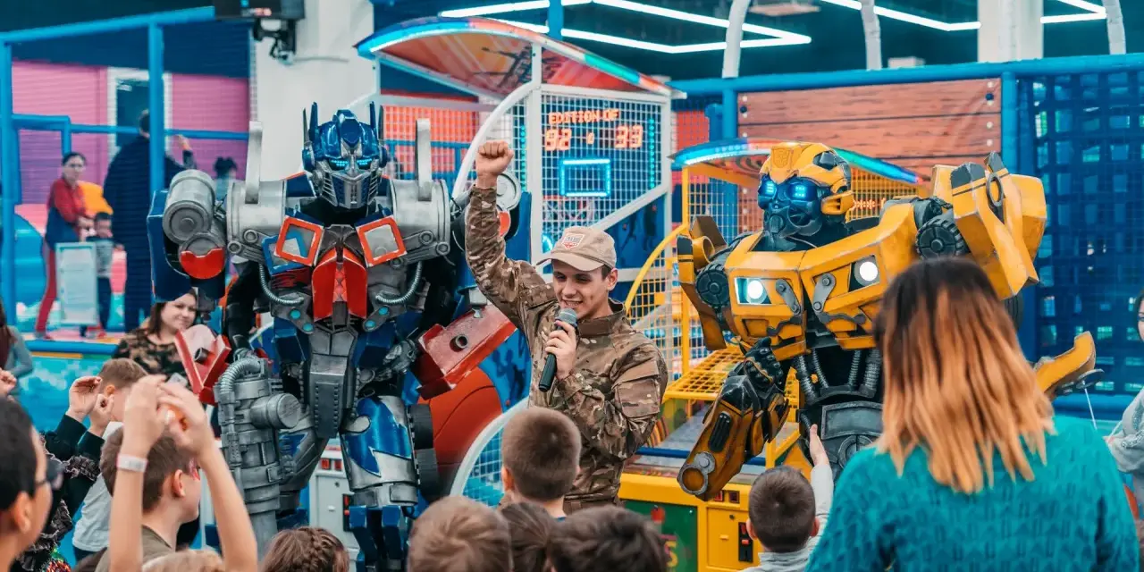 Wspaniałe urodziny! Dzieci cieszą się z obecności Optimusa Prime'a i Bumblebee, słuchając animatora.