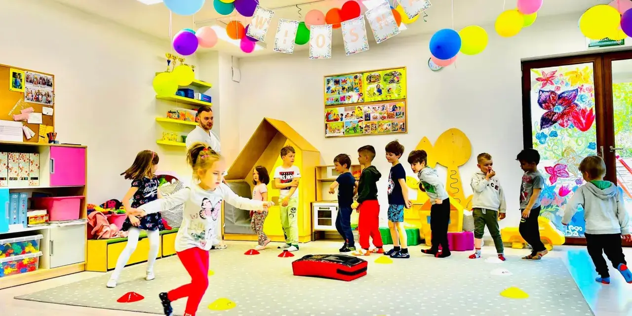 Kolorowe balony i girlandy ozdabiają salę, gdzie dzieci biorą udział w wesołych zajęciach plastycznych w przedszkolu.