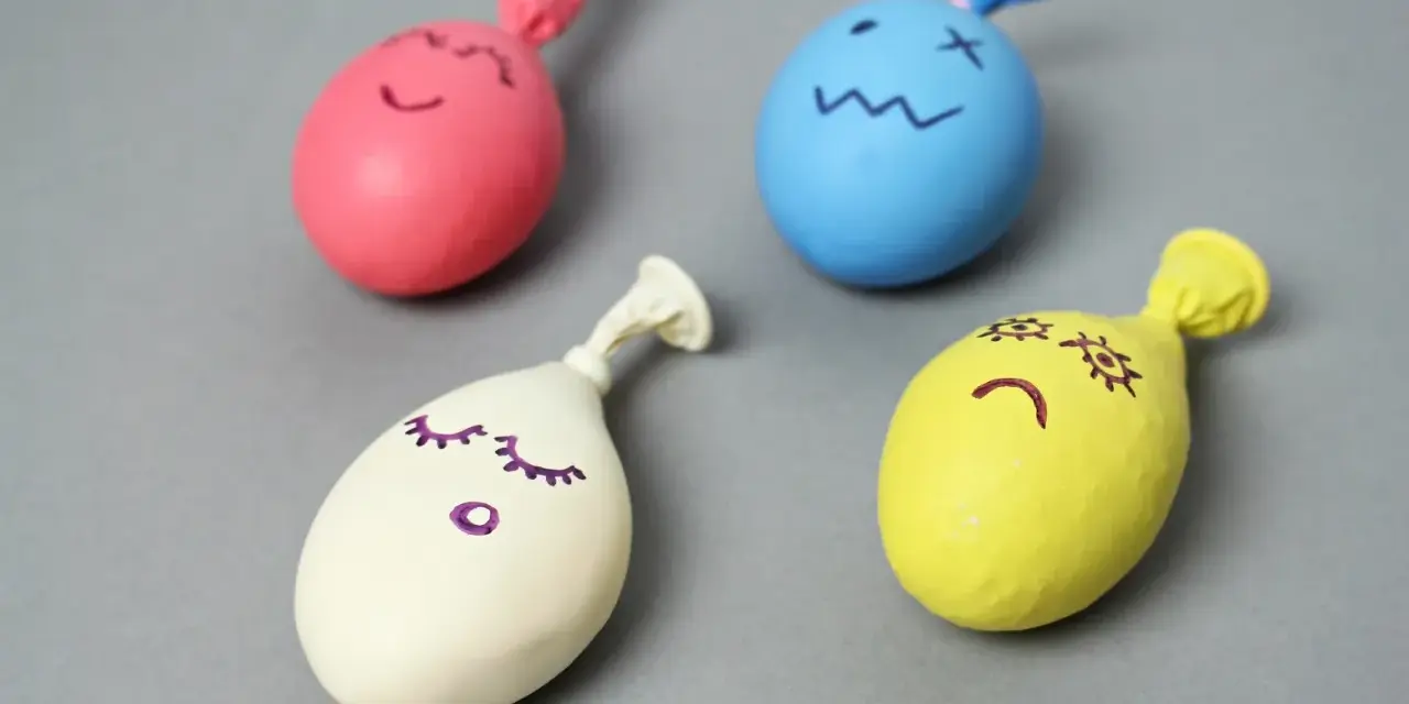 Cztery kolorowe balony z narysowanymi buźkami, gotowe do zabawy. Dowiedz się, jak zrobić gniotka!