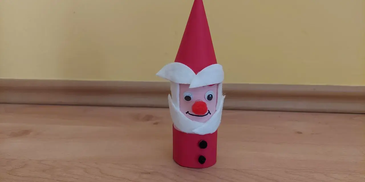 Urocza praca plastyczna Mikołaj z rolki papieru, z czerwonym noskiem i czarnymi guzikami.