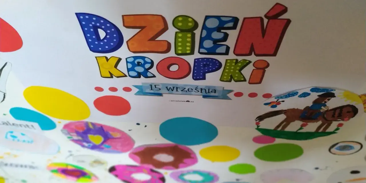 Kolorowa praca plastyczna na Dzień Kropki. Litery "Dzień Kropki" ozdobione kropkami, poniżej rysunki dzieci: konik z jeźdźcem, bałwanek i kolorowe kropki.