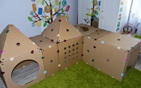 Zabawkowy domek z kartonu, który można łatwo złożyć, przypomina konstrukcję do zabawy w "jak zrobić ul z kartonu".
