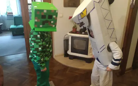 Dzieci w łatwych przebraniach z bajek: jeden w stroju Creepera z Minecrafta, drugi jako robot z kartonu.