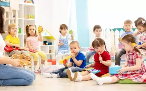 Wesołe zabawy w przedszkolu: dzieci grają na instrumentach, śpiewają i bawią się z nauczycielem.