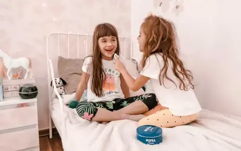 Radosne zabawy na urodziny 9 latki! Dziewczynki śmieją się, malując sobie noski kremem Nivea.