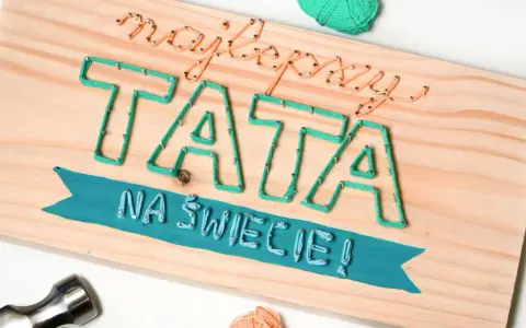 Własnoręczny prezent dla taty od dziecka: napis "Najlepszy TATA na świecie!" wykonany sznurkiem na desce.