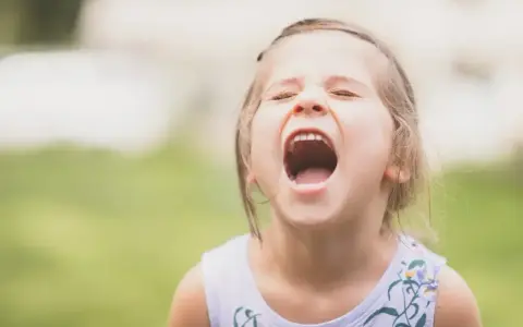 Mała dziewczynka krzyczy, wyrażając silne emocje. Widać, że 9 latek nie radzi sobie z nimi.
