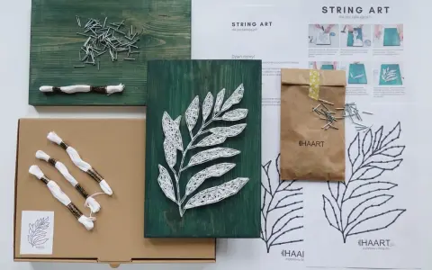 Zestaw do tworzenia string art z szablonami dla początkujących. Drewniana deska, gwoździe, biała nić i instrukcje.