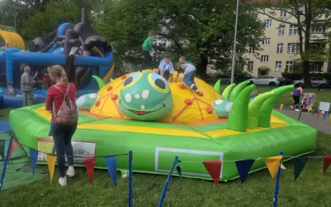Dzieci bawią się na dmuchanej gąsienicy, która jest jedną z atrakcji na dzień dziecka.