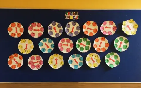 Praca plastyczna dla 3 latków: zegar emocji z uśmiechniętymi buźkami na talerzykach papierowych.