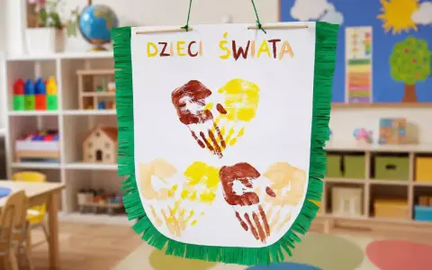Kolorowe odciski dłoni dzieci tworzą serca na plakacie "Dzieci Świata". Wspaniałe zajęcia plastyczne dla dzieci w przedszkolu.