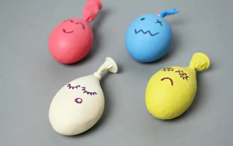 Cztery kolorowe balony z narysowanymi buźkami, gotowe do zabawy. Dowiedz się, jak zrobić gniotka!