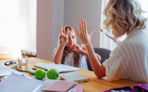 Dziewczynka uczy się liczyć w pamięci, pokazując palce. Mama cierpliwie tłumaczy, jak to zrobić.