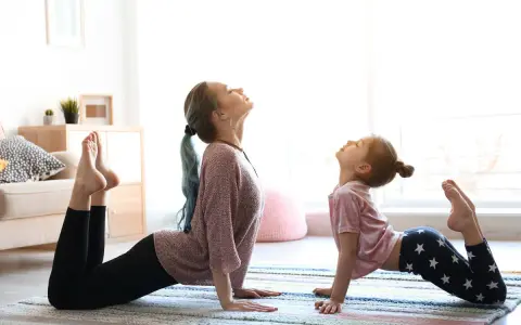 Mama i córka ćwiczą jogę dla 2 dzieci w pozycji kobry.