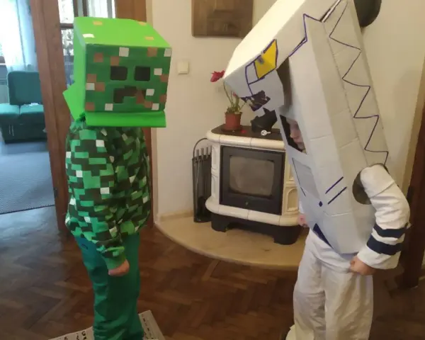 Dzieci w łatwych przebraniach z bajek: jeden w stroju Creepera z Minecrafta, drugi jako robot z kartonu.