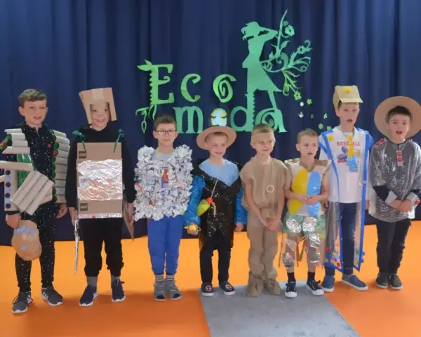 Chłopcy prezentują stroje ekologiczne wykonane z materiałów recyklingowych. Inspiracja, jak zrobić strój ekologiczny dla chłopca, widoczna na ich kreatywnych kreacjach.