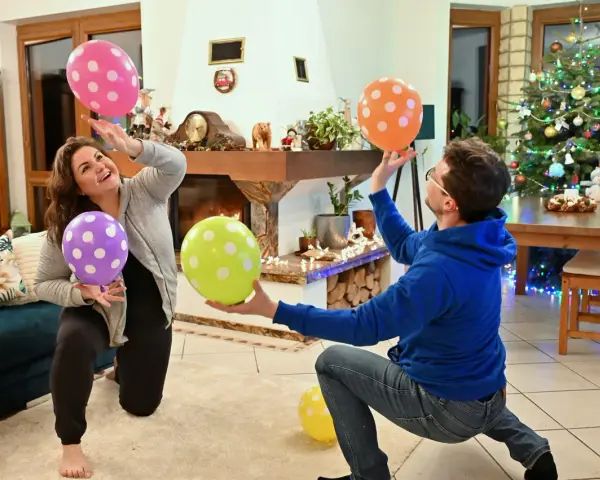 Para wiedzą, co robić, gdy się nudzi w domu: grają w balony przy choince.