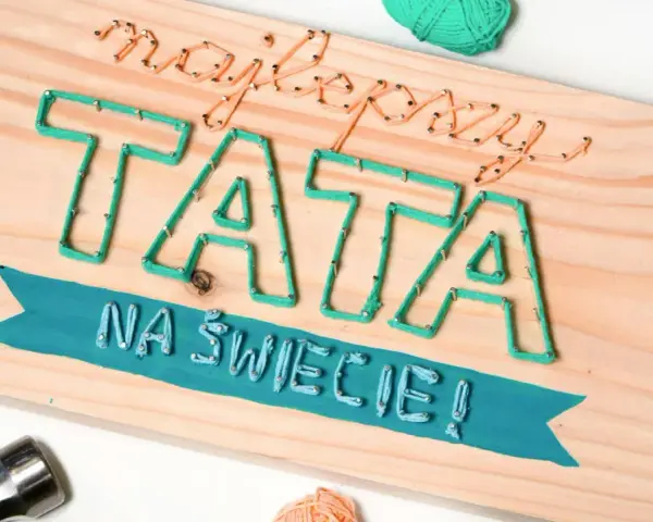 Własnoręczny prezent dla taty od dziecka: napis "Najlepszy TATA na świecie!" wykonany sznurkiem na desce.