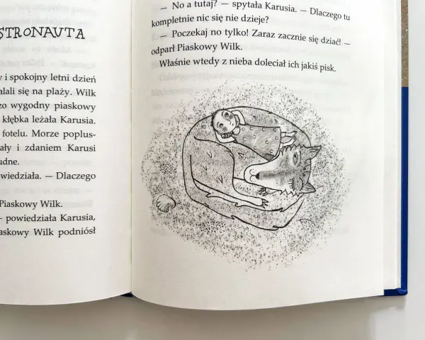 Ilustracja z książki: dziewczynka Karusia śpi wtulona w Piaskowego Wilka.