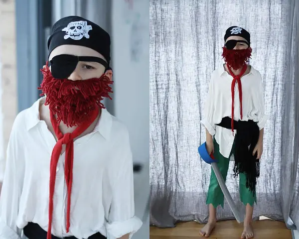Chłopiec w stroju pirata: czarna bandama z czaszką, opaska na oko, czerwona broda z włóczki i biała koszula. Jak zrobić strój pirata samemu?