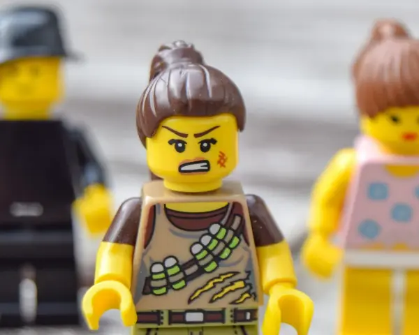 Trzy ludziki Lego. Jeden z nich, w brązowym stroju, ma zaciętą minę, co sugeruje nieradzenie sobie z emocjami.