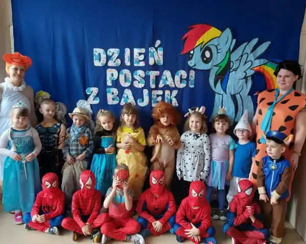 Dzień postaci z bajek w przedszkolu. Dzieci przebrane za Spider-Manów, księżniczki, zwierzątka i inne bajkowe postacie pozują do zdjęcia.