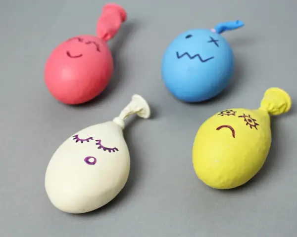 Cztery kolorowe balony z narysowanymi buźkami, gotowe do zabawy. Dowiedz się, jak zrobić gniotka!