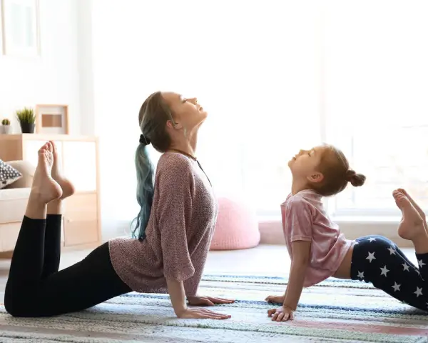 Mama i córka ćwiczą jogę dla 2 dzieci w pozycji kobry.