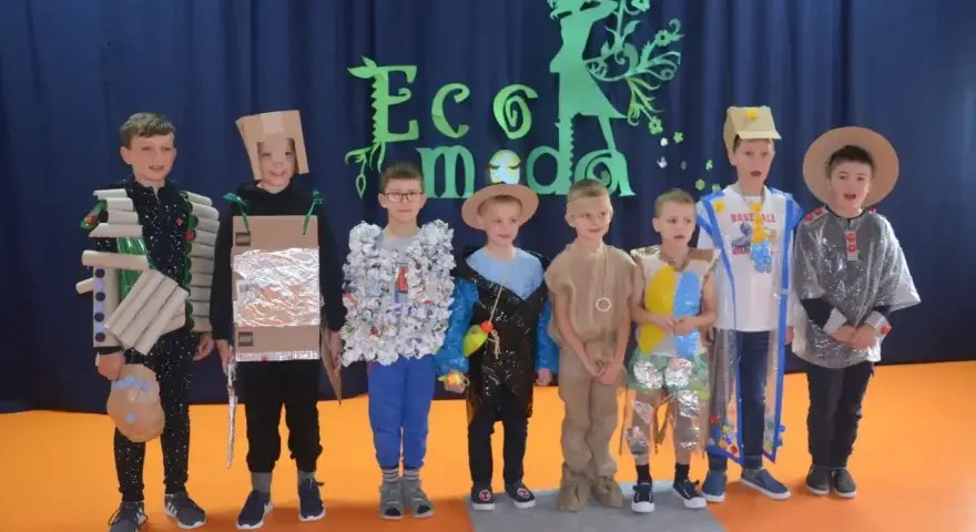 Chłopcy prezentują stroje ekologiczne wykonane z materiałów recyklingowych. Inspiracja, jak zrobić strój ekologiczny dla chłopca, widoczna na ich kreatywnych kreacjach.