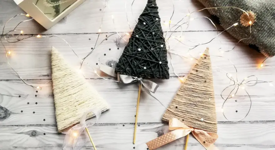 Urocza choinka z wykałaczek, ozdobiona wstążką i światełkami, tworzy magiczny, świąteczny nastrój.