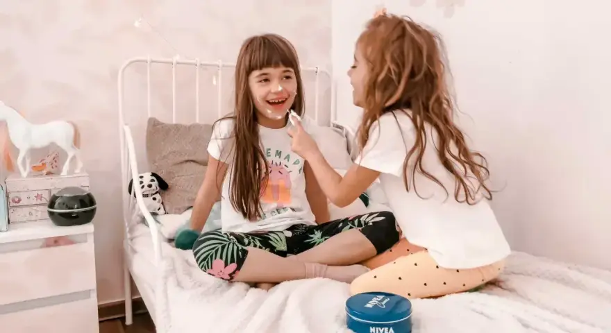 Radosne zabawy na urodziny 9 latki! Dziewczynki śmieją się, malując sobie noski kremem Nivea.
