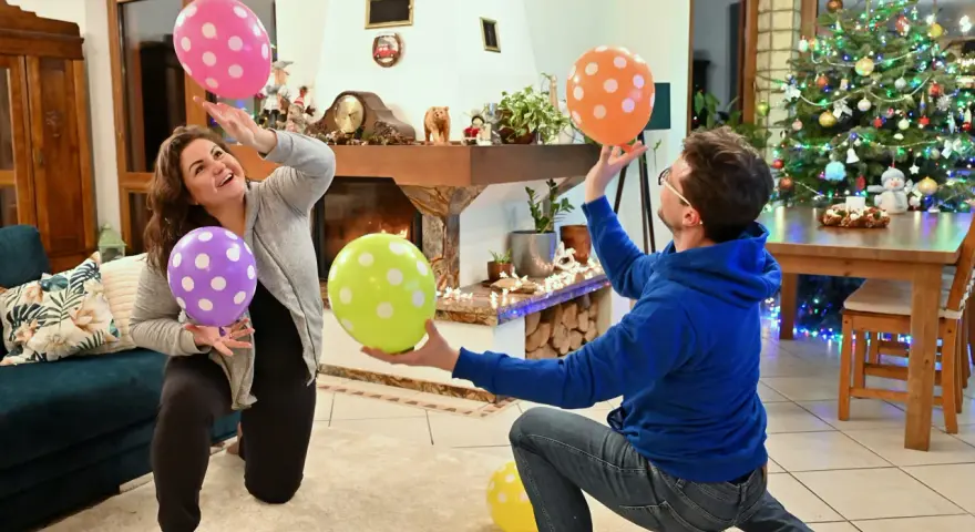 Para wiedzą, co robić, gdy się nudzi w domu: grają w balony przy choince.