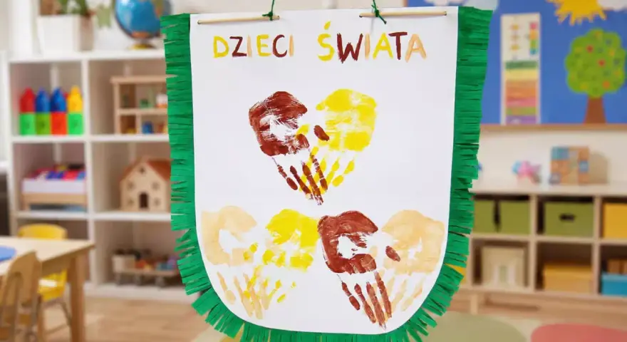 Kolorowe odciski dłoni dzieci tworzą serca na plakacie "Dzieci Świata". Wspaniałe zajęcia plastyczne dla dzieci w przedszkolu.