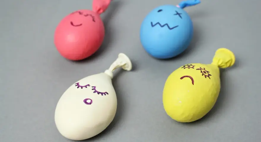 Cztery kolorowe balony z narysowanymi buźkami, gotowe do zabawy. Dowiedz się, jak zrobić gniotka!