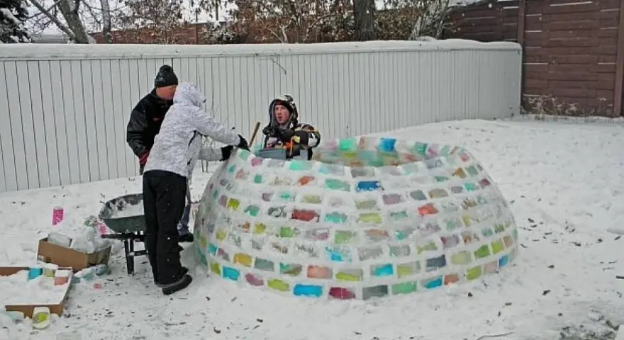 Rodzina buduje kolorowe igloo z lodu. Dzieci pomagają, układając bloki. Oto jak zbudować igloo!