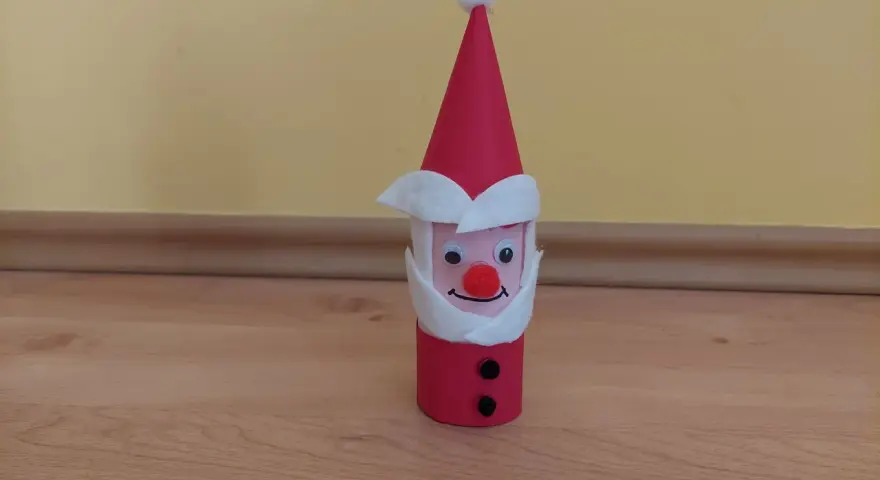 Urocza praca plastyczna Mikołaj z rolki papieru, z czerwonym noskiem i czarnymi guzikami.